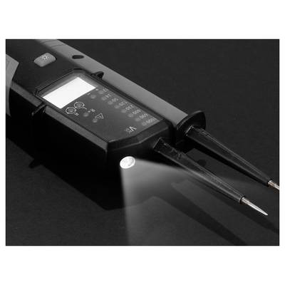 Digital voltage tester with two probe tips and a lit display, shown on a dark surface with the flashlight shining forward.