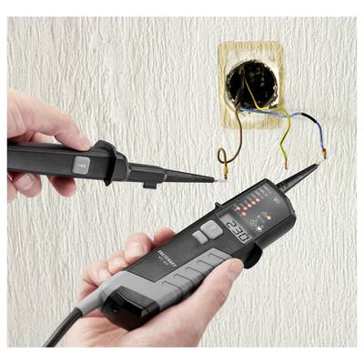Technician testing exposed wall wiring with a voltage detector and probe near an open electrical outlet box.<br>