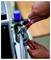 Close-up of hands using a red adjustable wrench to tighten a hose fitting on industrial machinery.