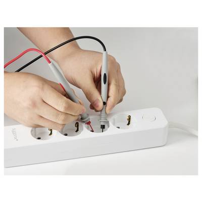'A person using multimeter probes on a power strip, checking the electrical current.'