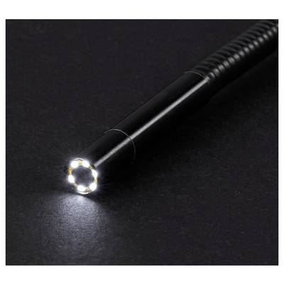 Black flashlight with a bright LED beam shining on a dark surface.