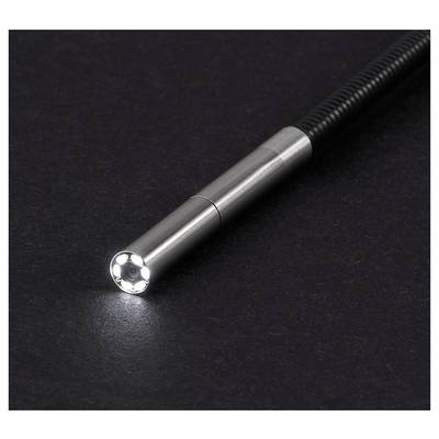 Close-up of a metallic flexible inspection camera probe on a black surface, with the round lighted lens facing forward.
