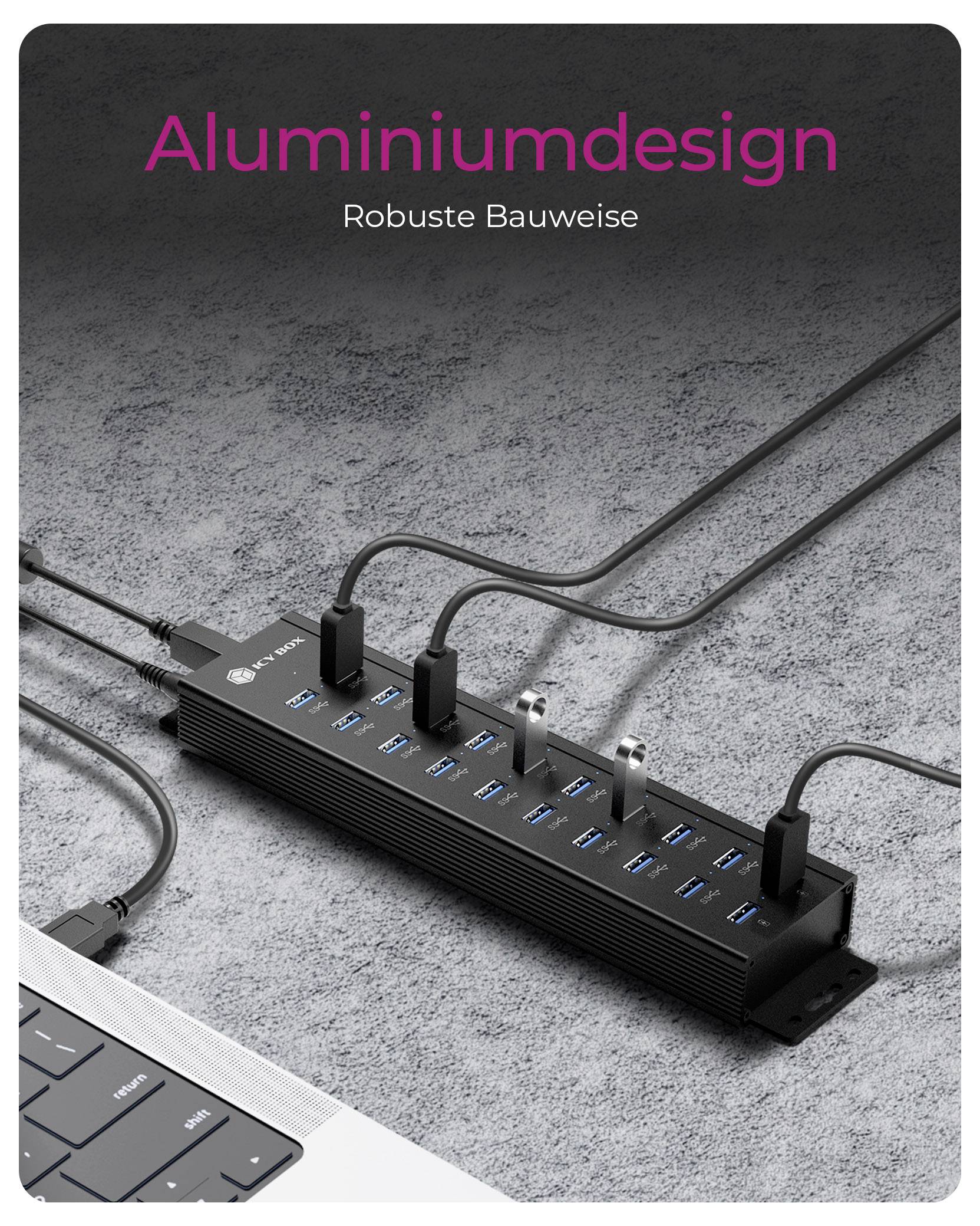 A black USB hub with multiple ports connected to cables, lying on a gray surface next to a laptop. Text reads 'Aluminiumdesign Robuste Bauweise'.