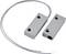 Magnetic sensor with rectangular metal casing and connecting cable, used in security systems to detect door or window opening.