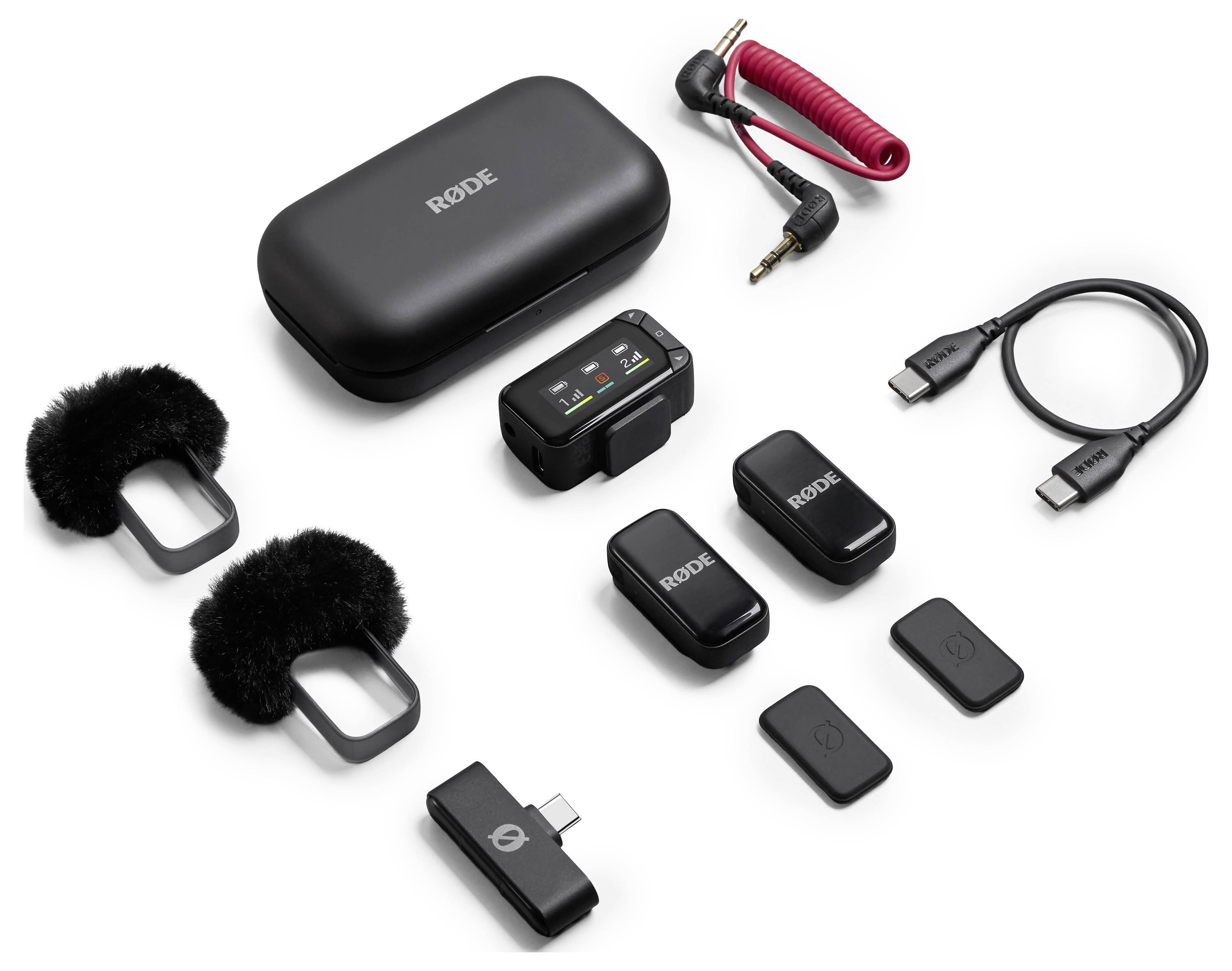 Wireless microphone kit with two black transmitters, a receiver, two windshields, USB cables, a TRS adapter, and a charging case.