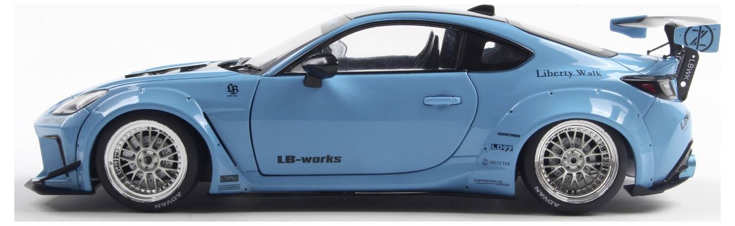 A blue sports car with modified bodywork and a large rear spoiler. It has 'Liberty Walk' decals and intricate silver alloy wheels.