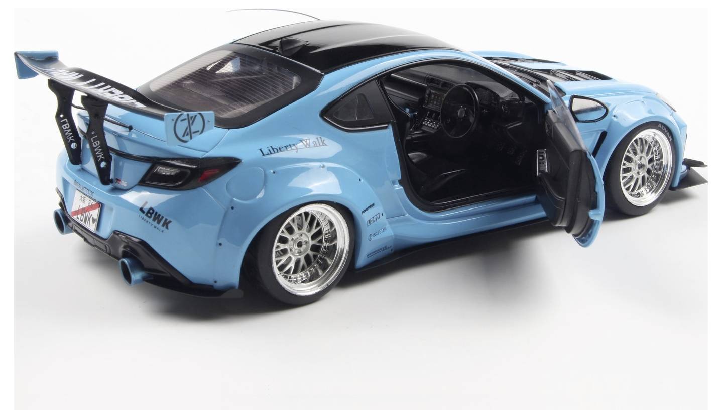 A bright blue sports car with a spoiler and custom rims is shown with the driver's door open, highlighting a sleek, modified design.