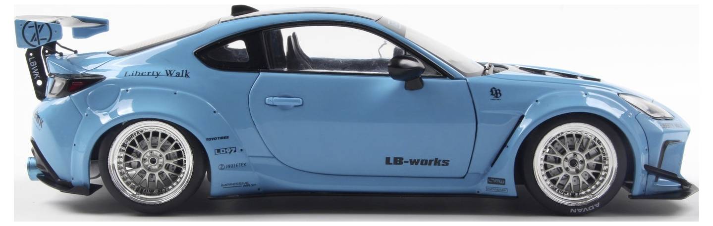 A blue sports car with custom wheels and body kit, featuring 'Liberty Walk' and 'LB-works' branding, viewed from the side.