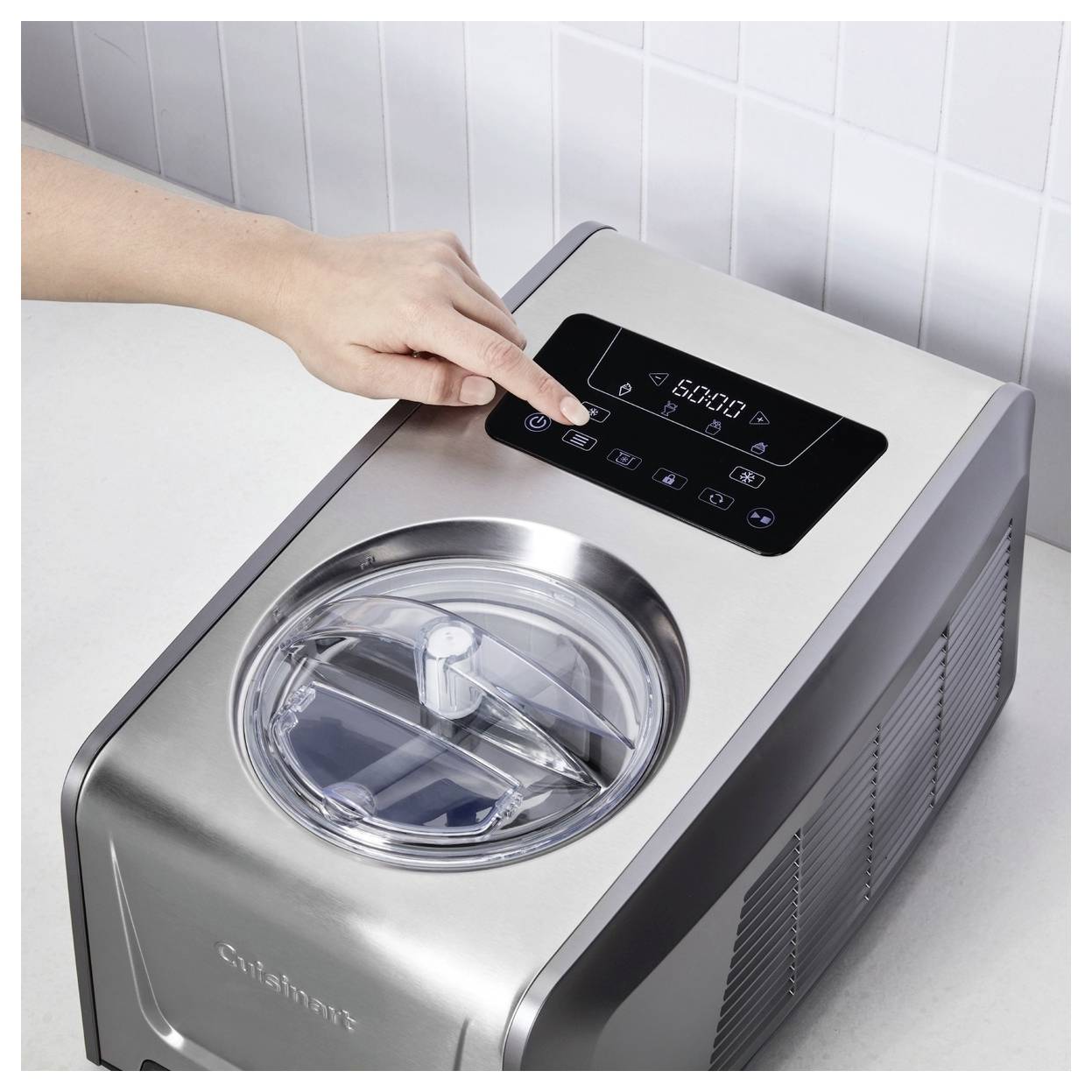 Person adjusting settings on a stainless steel ice cream maker. The machine has a digital display showing '60:00'.