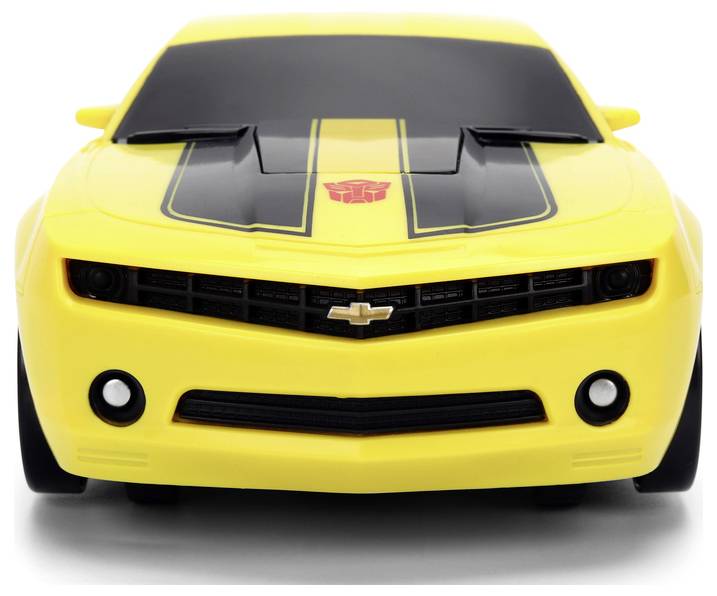 A yellow toy car with black racing stripes and a red emblem on the hood, resembling a sports model.
