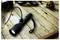 A black flashlight connected to a charging cable rests on a rustic wooden surface beside small objects, suggesting a vintage theme.