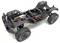 A black RC truck chassis with exposed wiring and large knobby tires, showcasing its internal structure and components.
