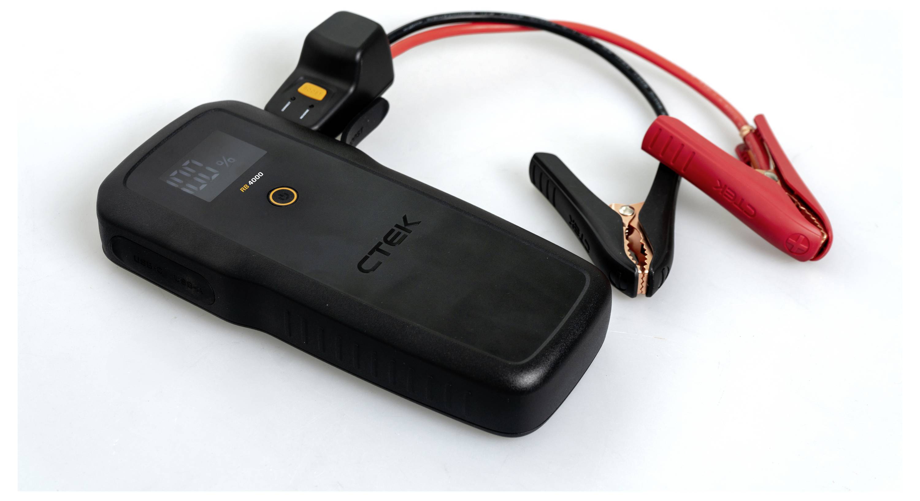 A portable car battery charger with a digital display, showing attached black and red jumper cables for charging car batteries.
