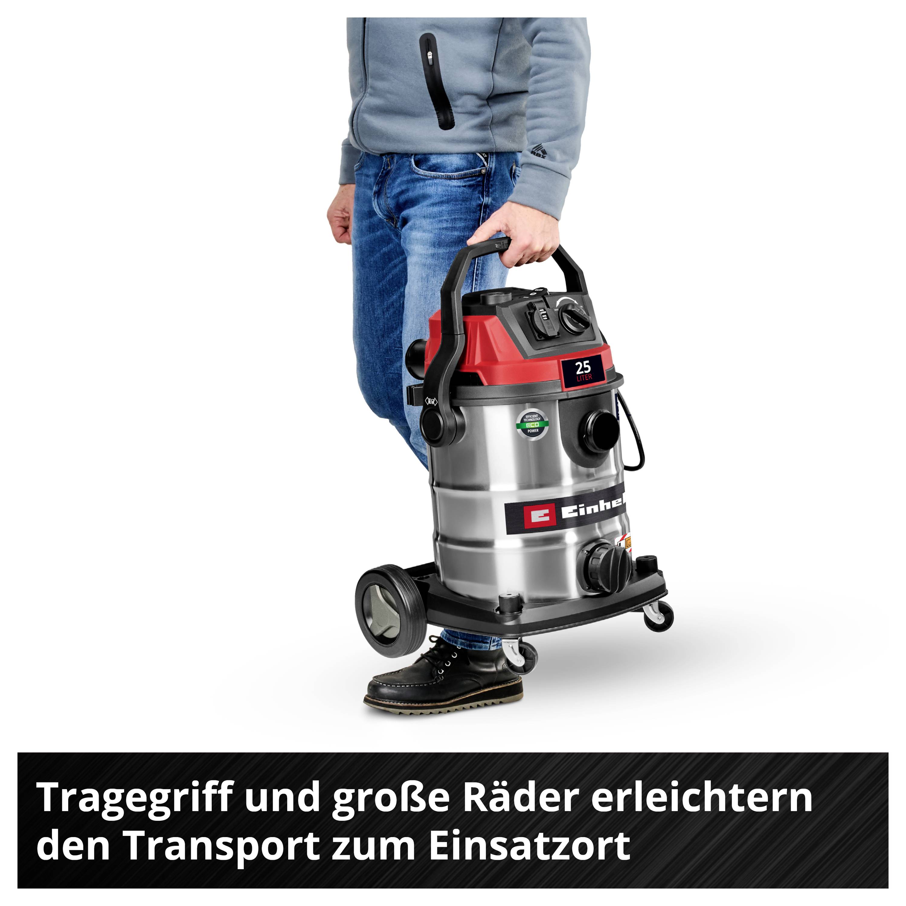 'Person is transporting a vacuum cleaner with large wheels and a carrying handle. Text: "Carrying handle and large wheels make transportation to the site easier."'