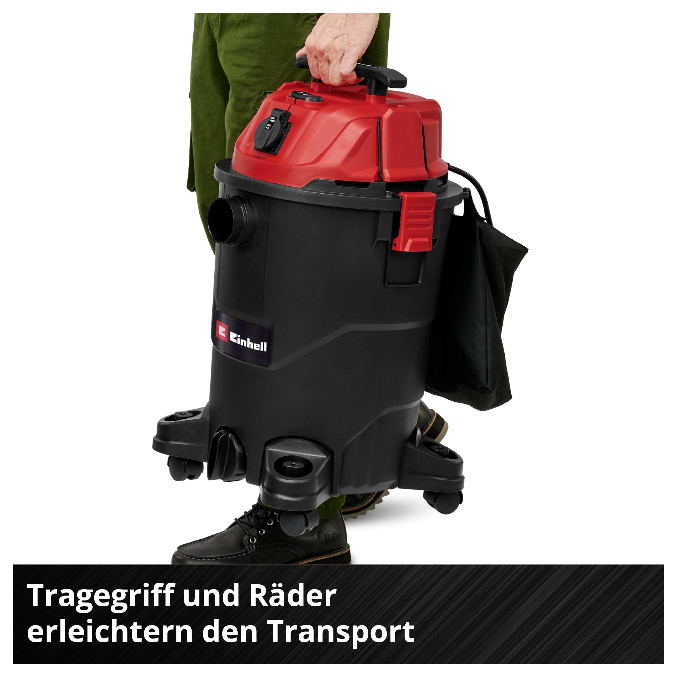 A red and black vacuum cleaner with a carry handle and wheels is being transported. Text: 'Carry handle and wheels make transportation easier'.