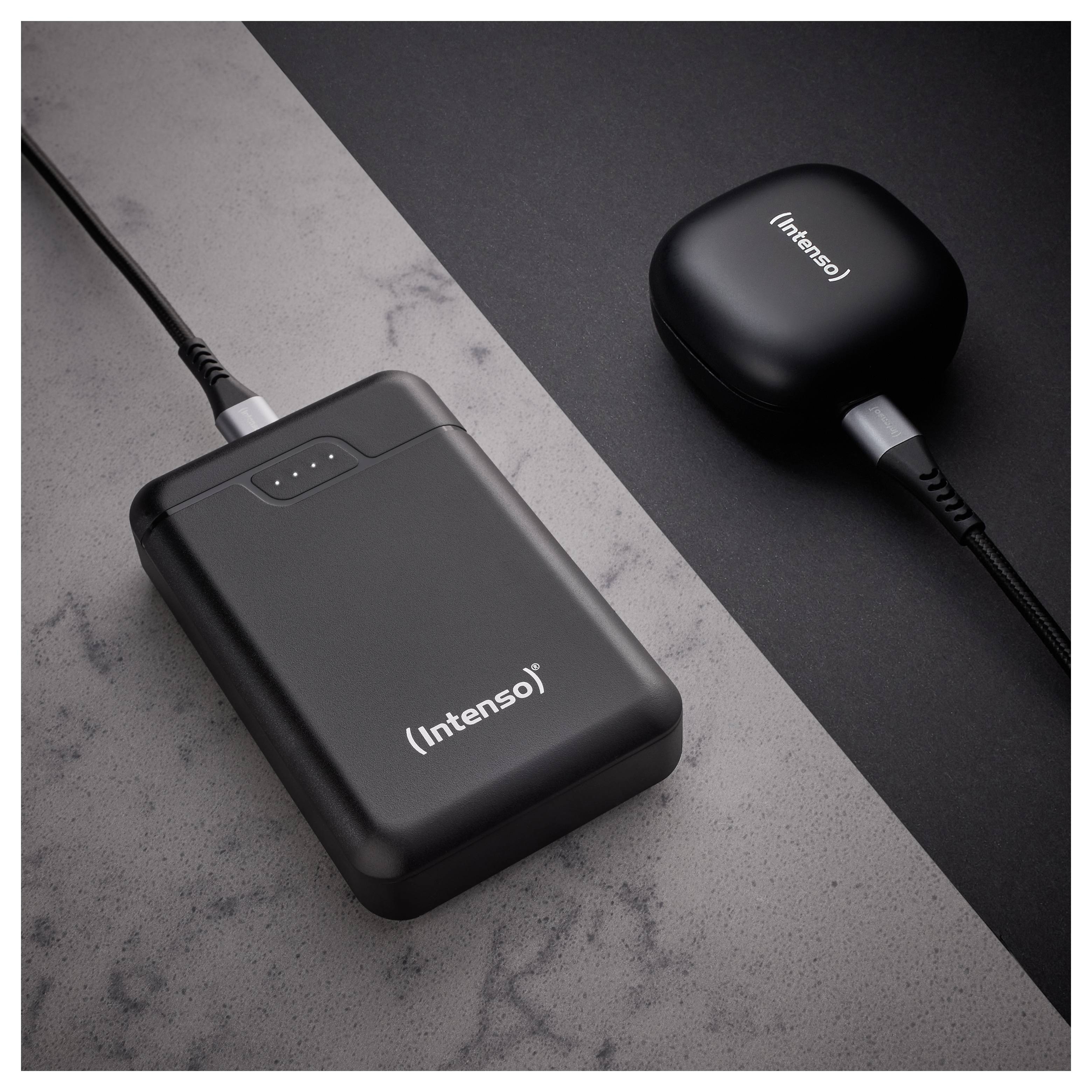 A black portable charger labeled 'Intenso' with charging cable connected, placed on a gray and black surface. Another compact device sits nearby.