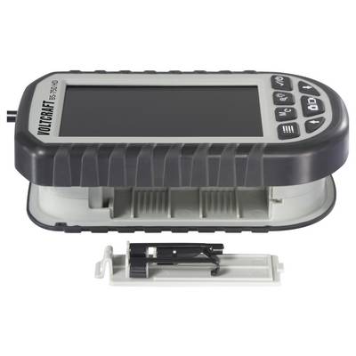 A voltmeter labeled 'VOLTCRAFT BS-150 XHD' with a screen and control buttons, placed next to an open battery compartment cover.