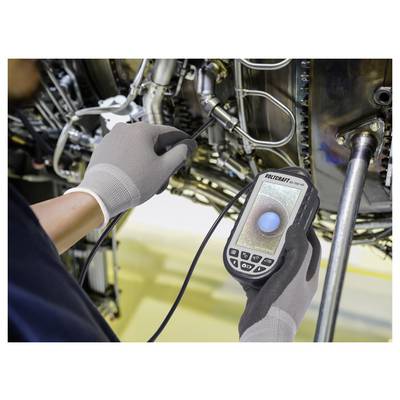 A technician inspects an aircraft engine using a handheld borescope camera, displaying a detailed view of internal components on its screen.