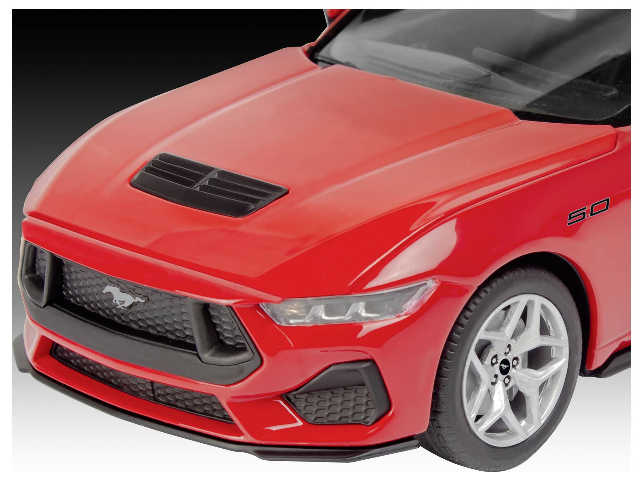 A red sports car model with a visible black grille and '5.0' badge on the side, suggesting a high-performance engine.