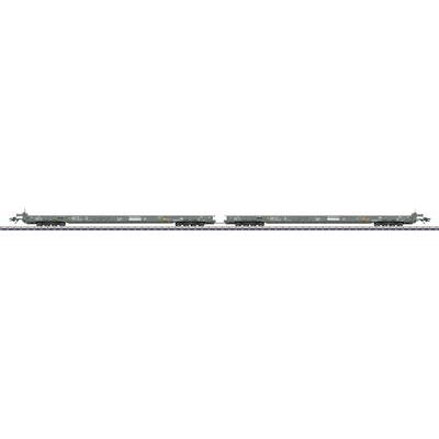 A gray, two-car rail transporter with flatbed structure and multiple axles is on the tracks, possibly intended for heavy cargo or equipment transport.