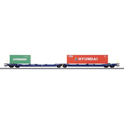 A train flatcar carries two shipping containers: a green one labeled 'EVERGREEN' and a red one labeled 'HYUNDAI', on railway tracks.
