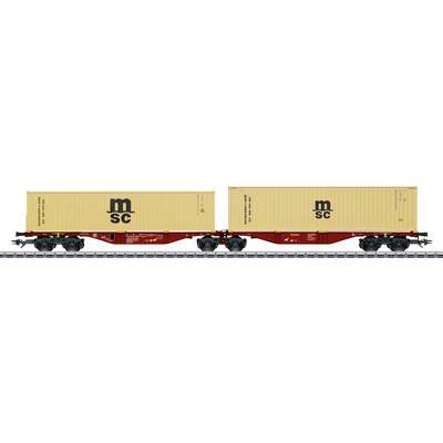 Two connected freight train cars carrying beige shipping containers marked 'MSC' on railroad tracks.