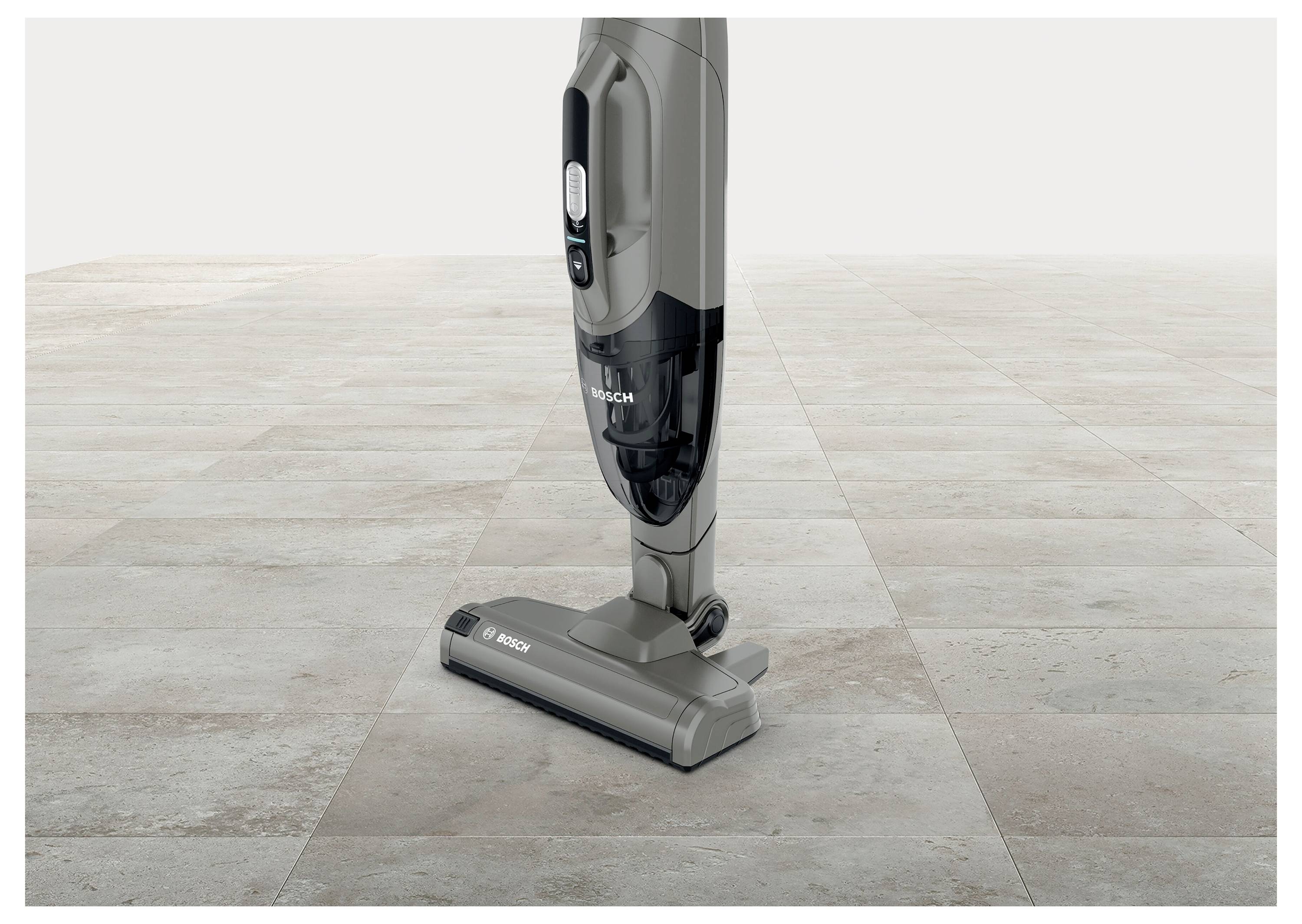 A cordless vacuum cleaner on a tiled floor, shown in a side view, emphasizing its sleek design and portability.