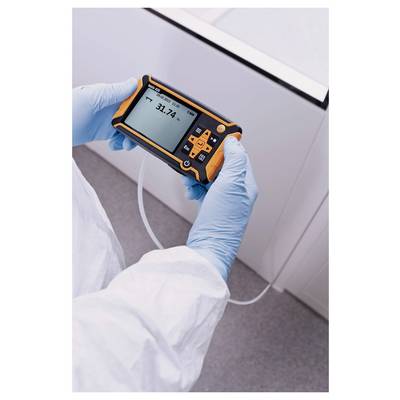 A person in protective gear holds a digital device displaying '31.2°C', possibly measuring temperature, connected to tubing in a lab setting.
