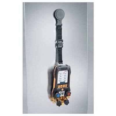 A digital manifold gauge with a display showing measurements, hanging vertically with a strap on a metallic surface.