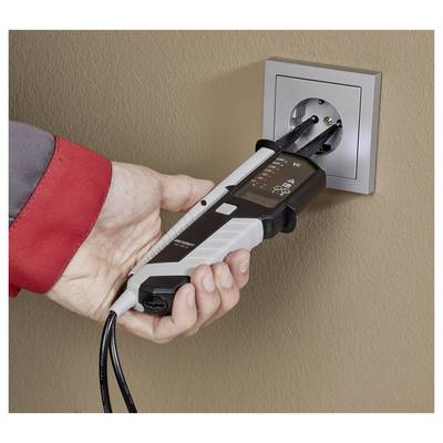 Handheld electrical outlet tester plugged into a wall socket, with indicator lights lit as it checks the outlet.