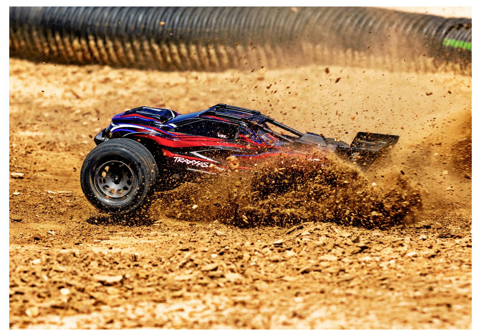 A remote-controlled car racing through dirt, kicking up dust and debris, with a blurred background indicating high speed.