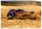 A remote-controlled car racing through dirt, kicking up dust and debris, with a blurred background indicating high speed.