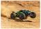 A remote-controlled truck with black and green accents kicks up dust as it speeds across a dirt track, capturing motion and excitement.