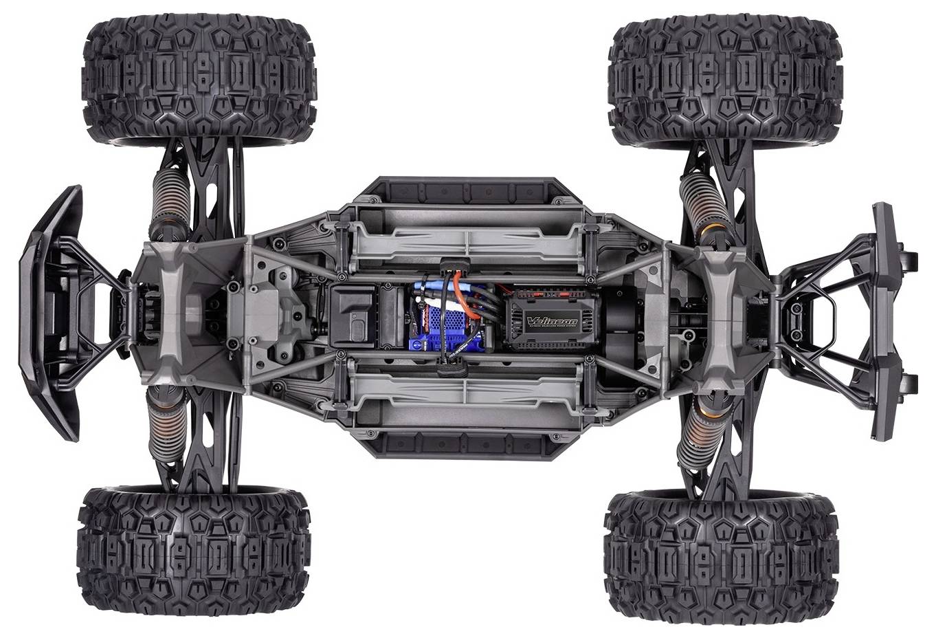 Overhead view of a detailed model car chassis with four large, rugged tires, showing components such as shocks and wiring inside.