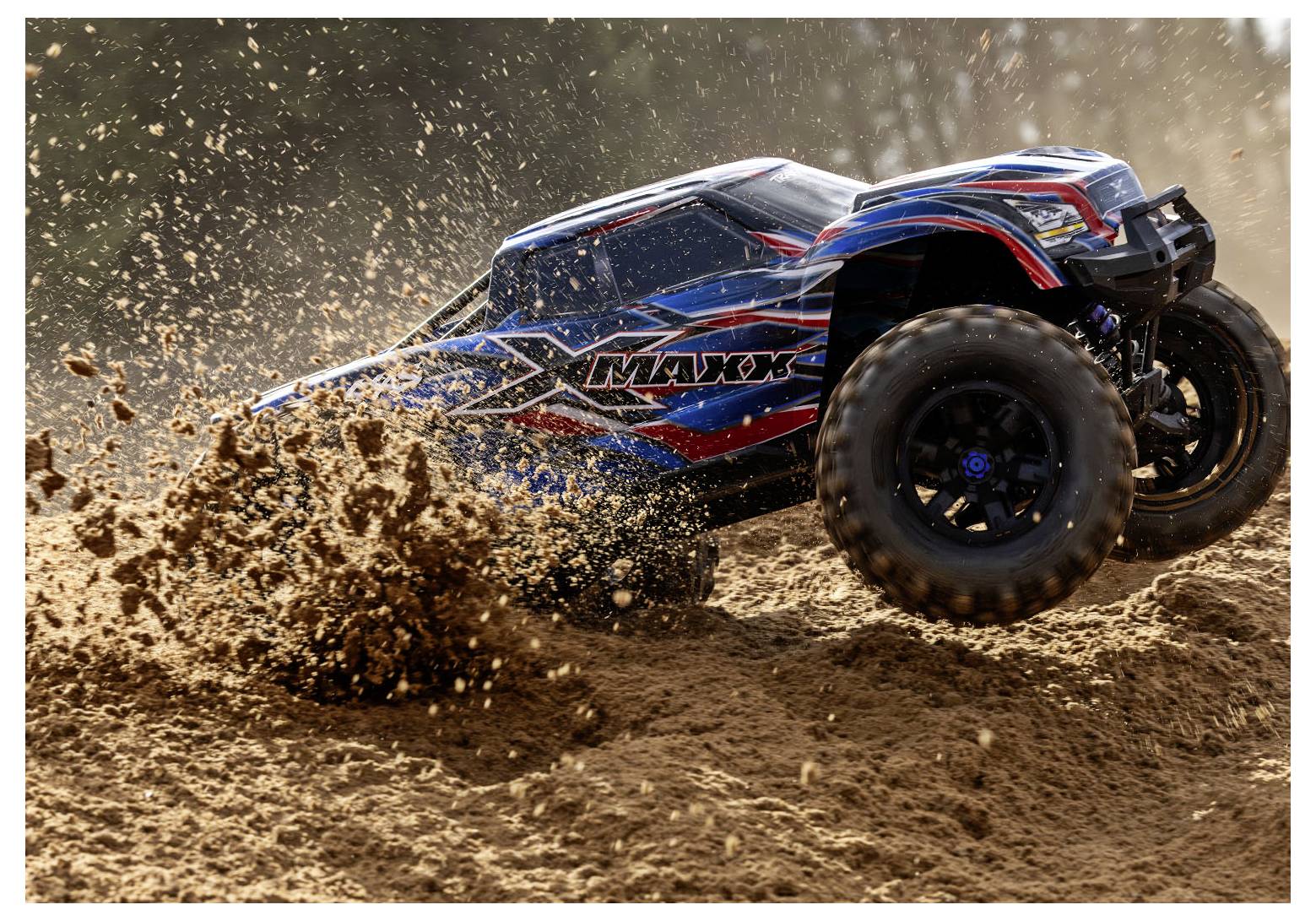 A remote-controlled truck with a blue and red design speeds through sand, kicking up dirt, showcasing off-road capabilities.