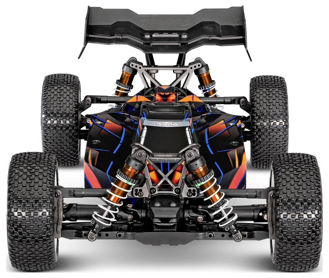 A remote-controlled car, viewed from the front, features a vibrant orange and black design, showcasing its suspension and large tires.