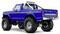 A bright blue lifted pickup truck with large off-road tires and a rear roll bar, viewed from the back angle.
