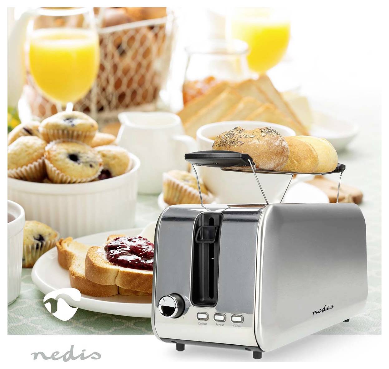 A silver toaster with toast and pastries next to a breakfast spread including muffins, orange juice, and jars of jam.