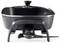A black electric skillet on a stand with a lid and temperature control dial.