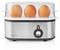 A stainless steel egg cooker with a transparent lid contains three brown eggs, indicating it is in use.