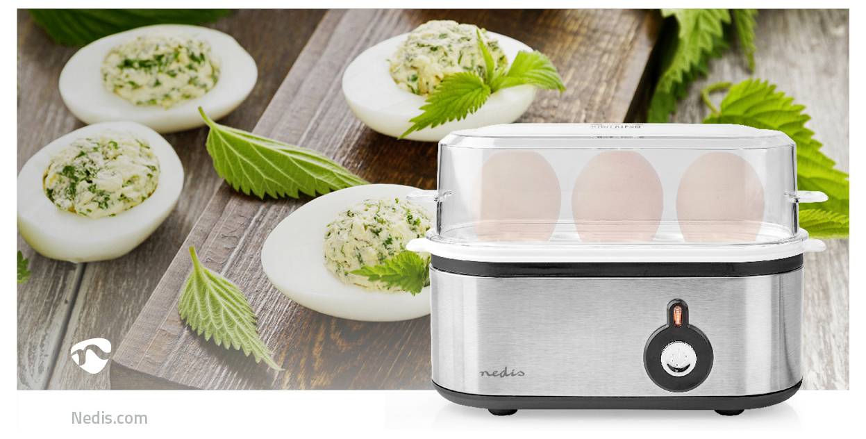'Egg cooker with stainless steel base alongside a wooden board featuring halved eggs filled with herb mixture and garnished with leaves.'