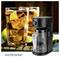 A black coffee maker with a glass carafe is placed next to a large glass of iced tea with lemon and lime slices.