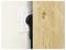 A black power plug is inserted into a white electrical socket with a wooden panel close to it, showing limited space for the plug.