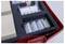 'Laboratory kit containing slides, vials, and cardboard pieces arranged in a foam holder within a red plastic case.'