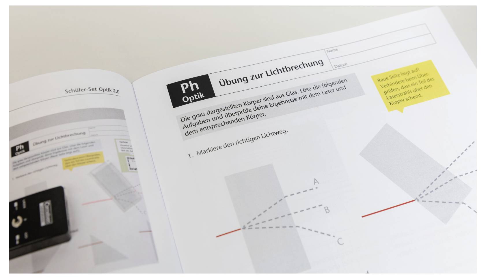 Open physics workbook page titled 'Übung zur Lichtbrechung' with diagrams illustrating light refraction concepts and related tasks.