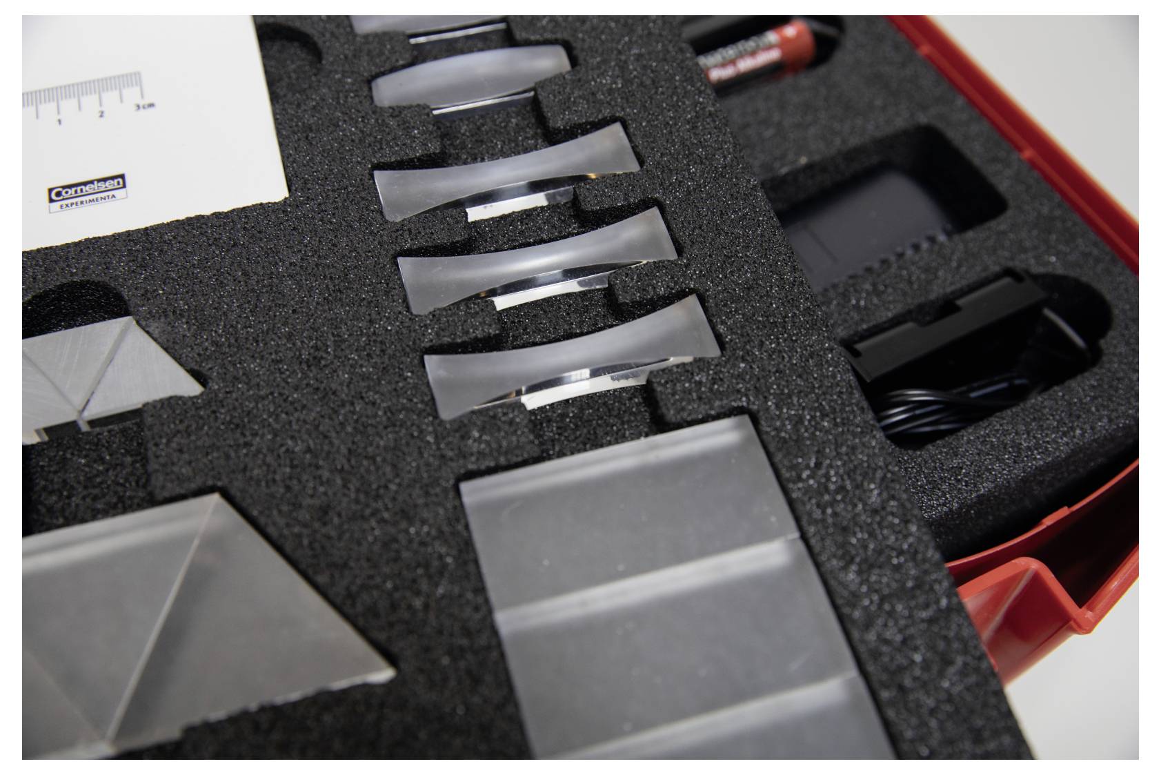 A case containing lenses and optical components organized in foam slots for protection and easy transport.