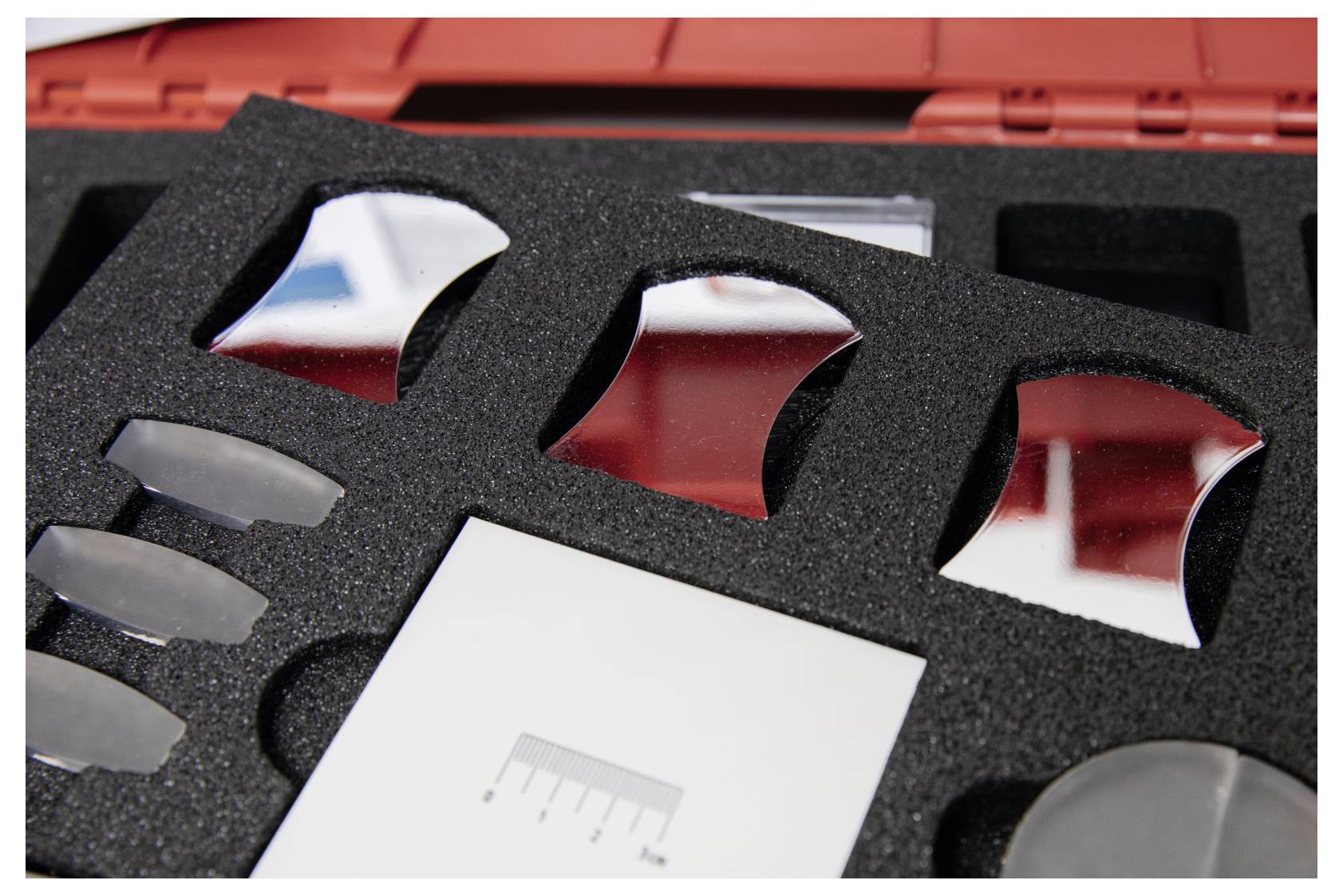 Calibration kit with mirrors and measurement tools in foam casing, used for precision adjustments in technical equipment.