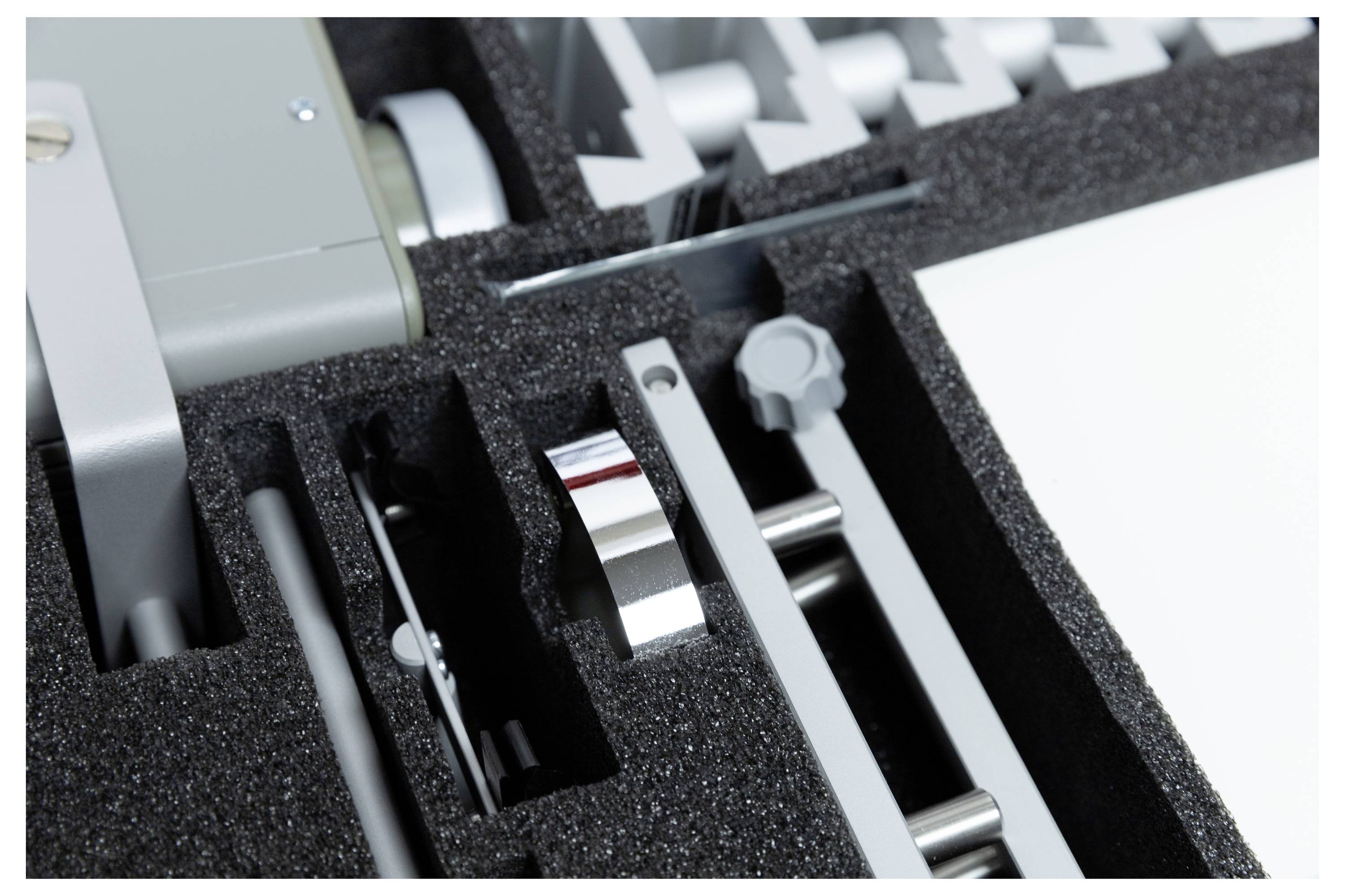 Foam packaging with precise cutouts holds metal and electronic components securely, indicating organization and protection.