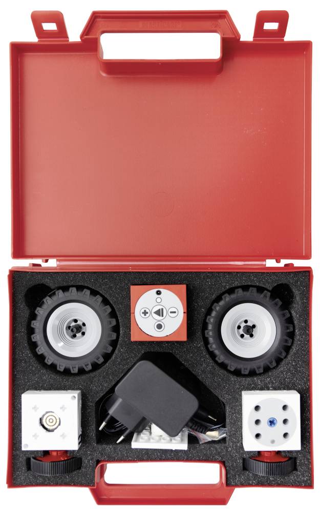 'Robotics kit in a red case containing wheels, motors, and a power adapter, organized within a foam insert.'