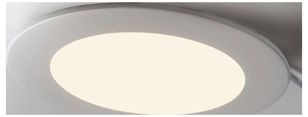 A round, recessed ceiling light emits a soft, warm glow, illuminating the area with a modern design.